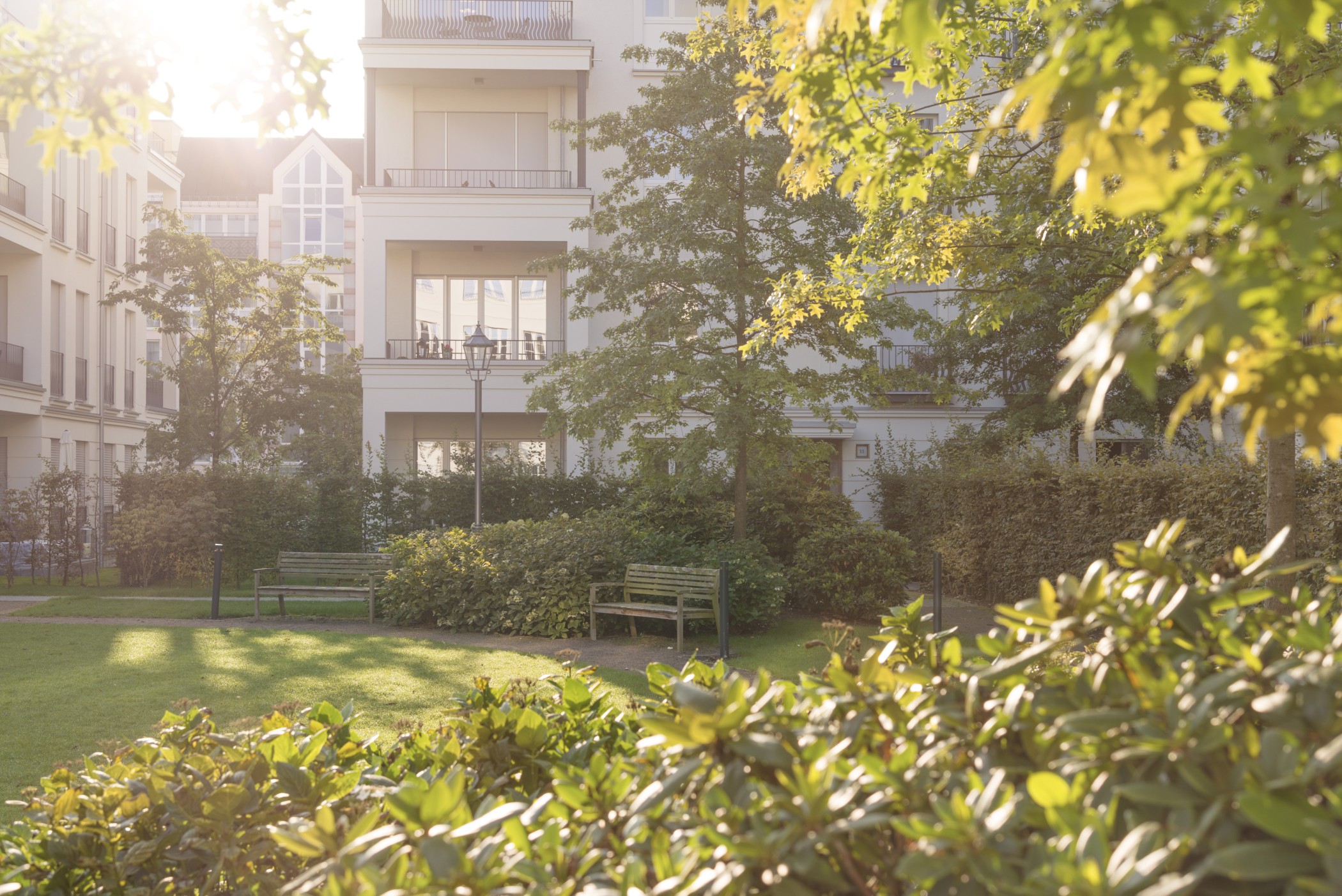 Parkanlage mit gepflegten Grünflächen vor der eleganten Architektur der Heinrich-Heine-Gärten in Düsseldorf