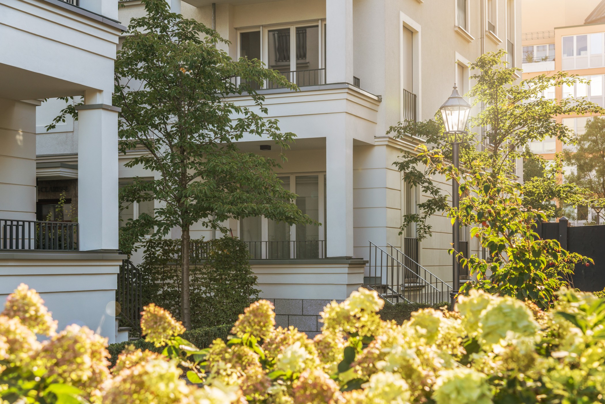 Blühende Parkanlage mit gepflegten Grünflächen vor der eleganten Architektur der Heinrich-Heine-Gärten in Düsseldorf