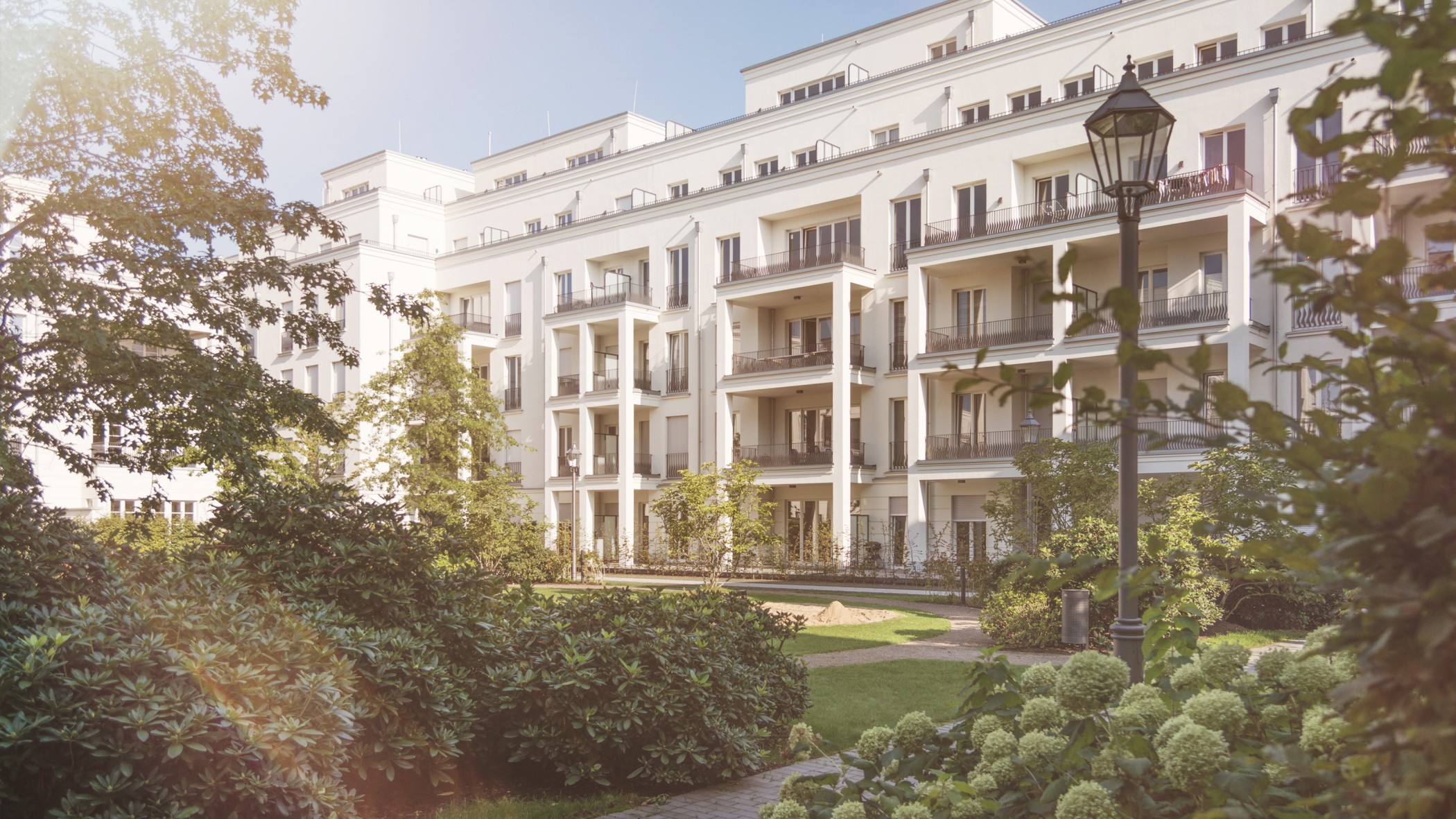 Parkanlage mit gepflegten Grünflächen vor der eleganten Architektur der Heinrich-Heine-Gärten in Düsseldorf